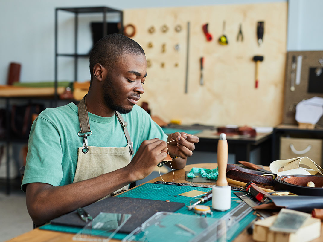 Young African American man in a workshop working with tools.