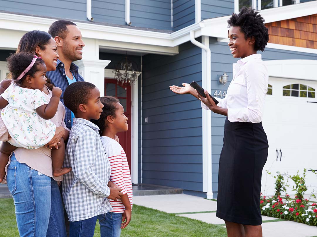 African American realtor showing a house to a mixed race family